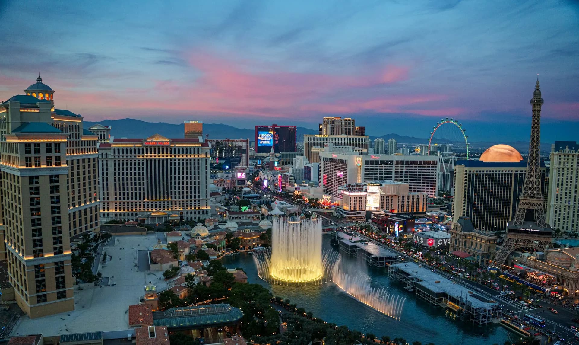 Twilight view of the Las Vegas Strip skyline near midtown condo towers. Las Vegas Strip skyline at twilight with Bellagio fountains and high-rise resorts — midtown condo living near the Strip